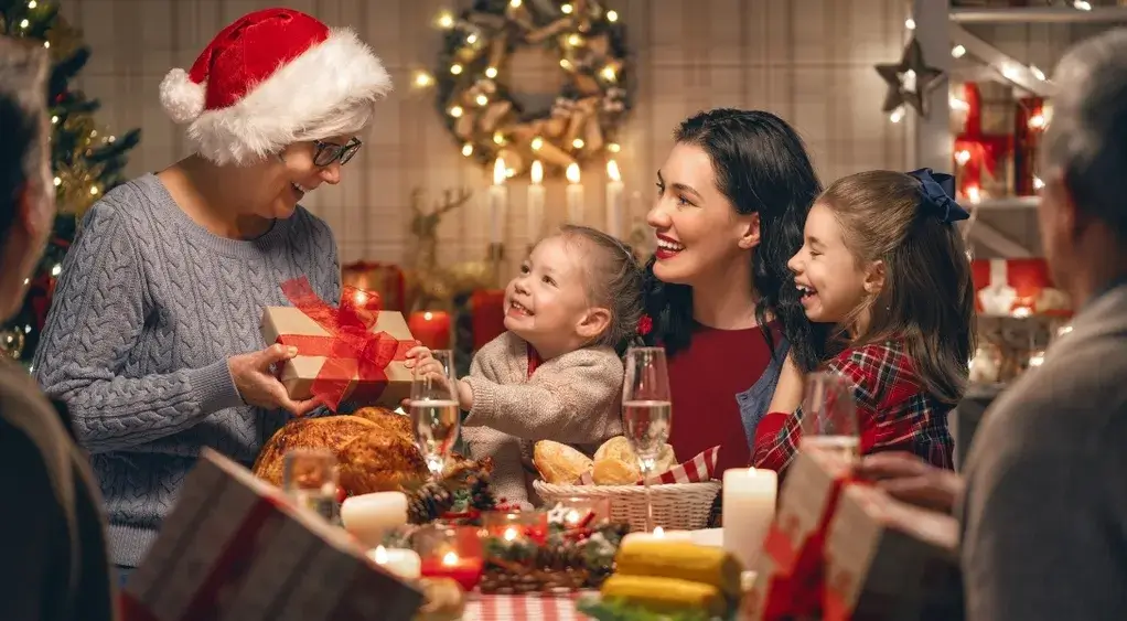 Family sharing gifts and holiday dinner, celebrating Christmas together in a cozy festive setting