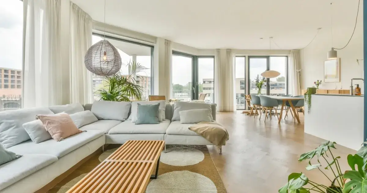 Bright and organized open-concept living room showing the importance of a clean house.
